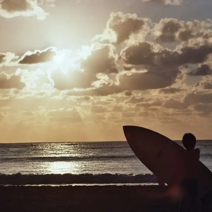 Surfeur au coucher de soleil, côte sud de l'île Maurice