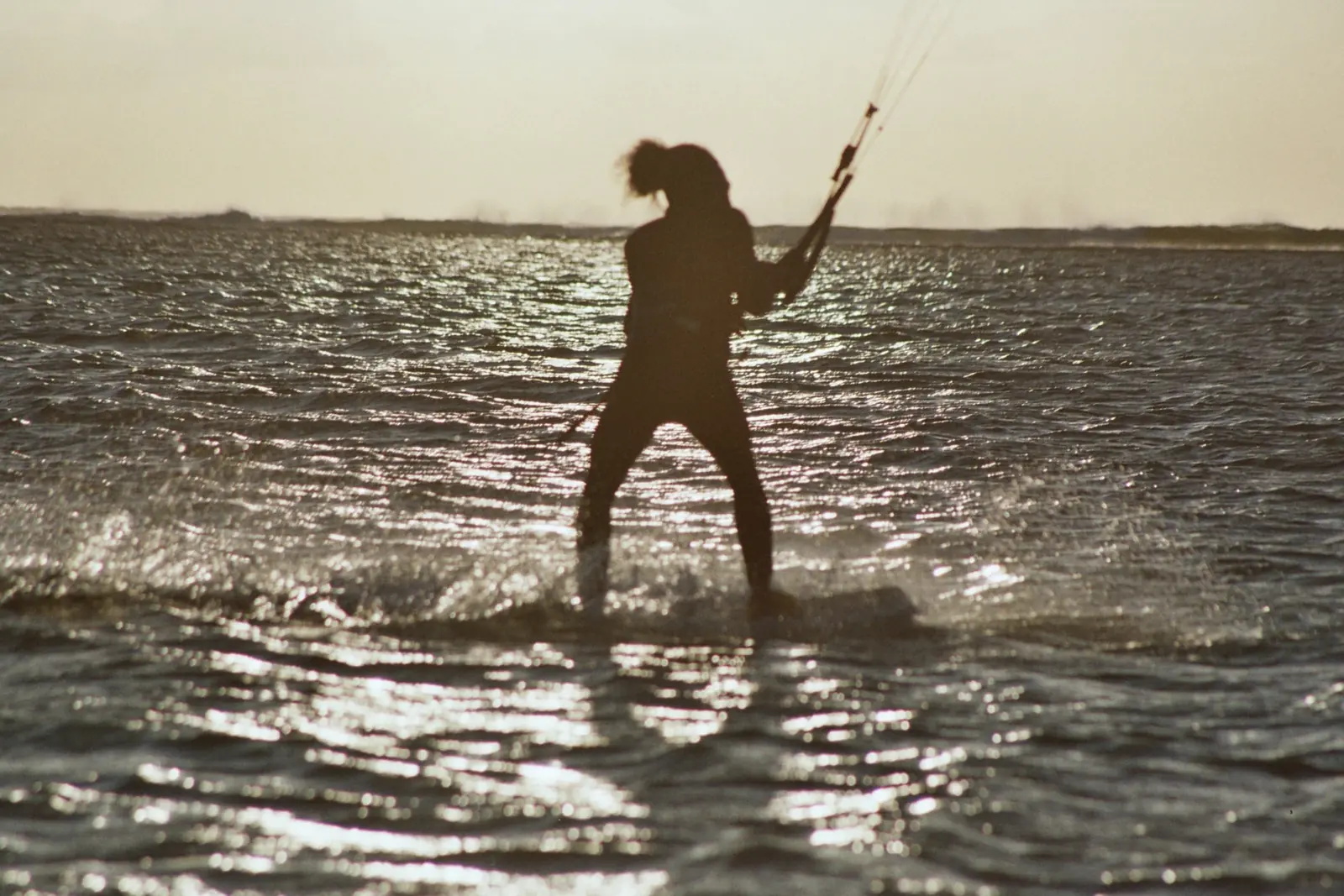Kitesurfeuse en contre-jour sur le lagon du Morne, île Maurice